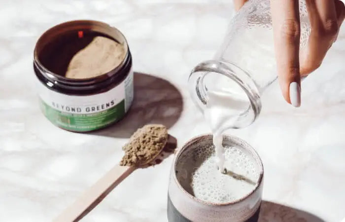 Live Conscious Beyond Greens next to a cup with milk being poured in