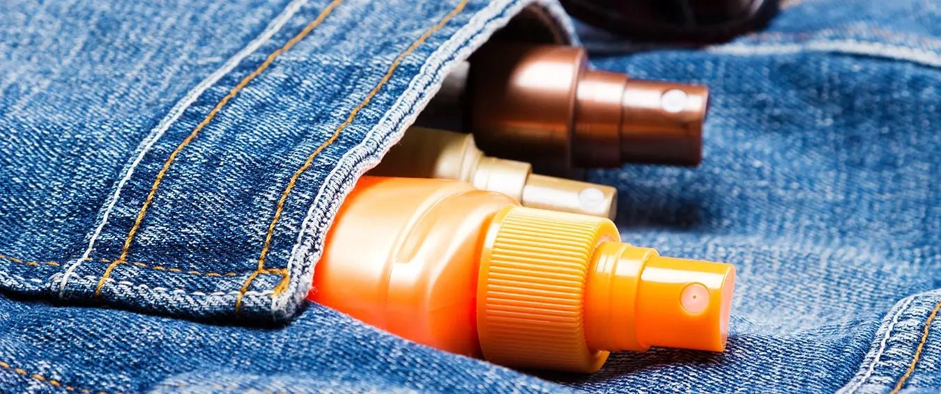 sunscreen spray bottles in a denim pocket