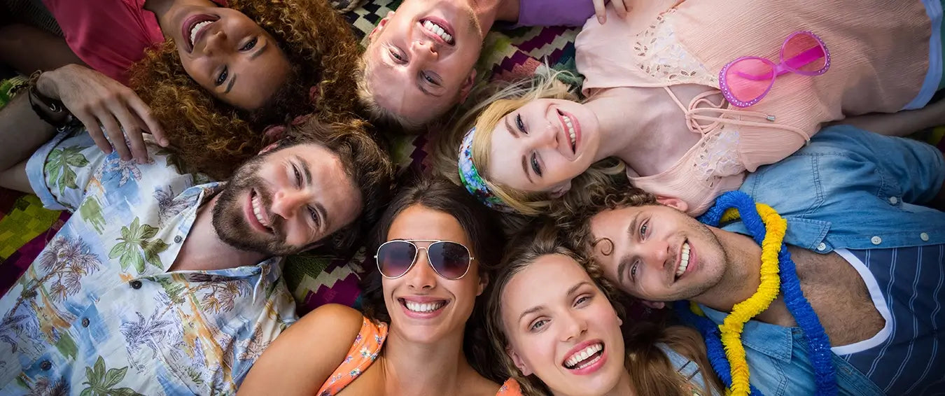 happy group of friends lying on the floor smiling at the camera