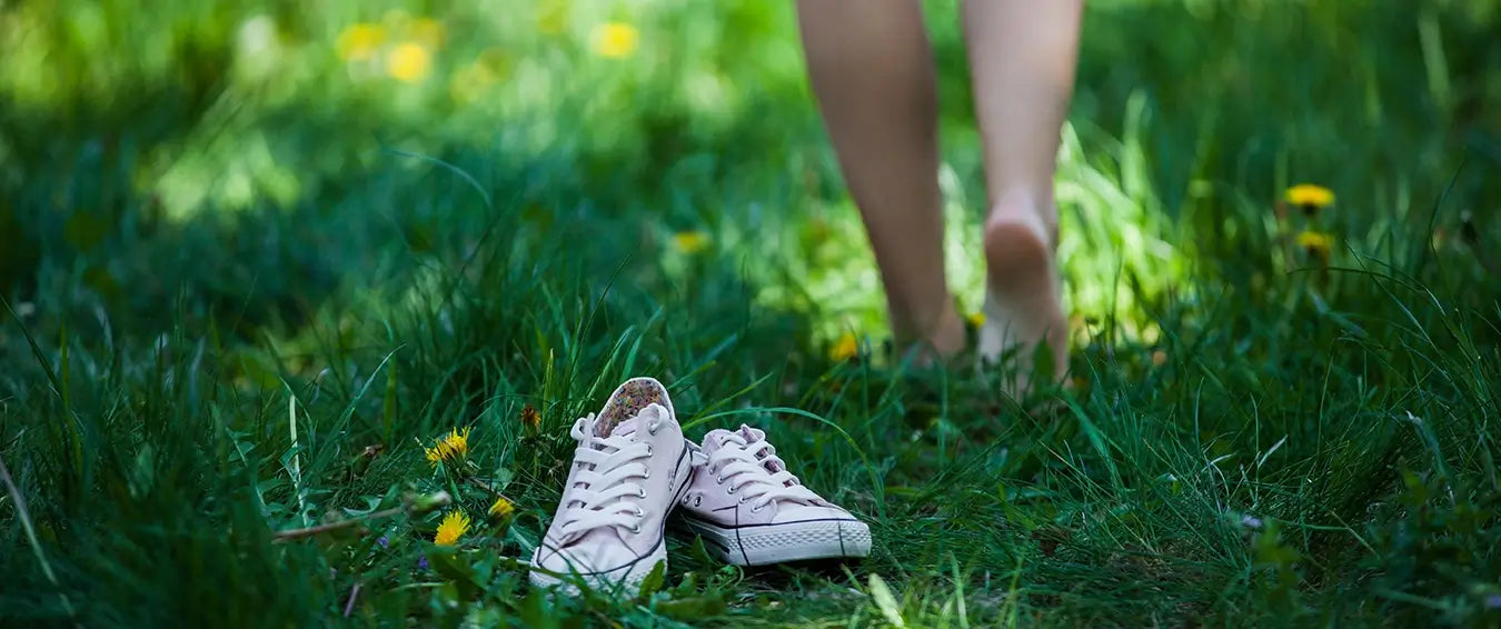 woman leaving her shoes and walking on the grass