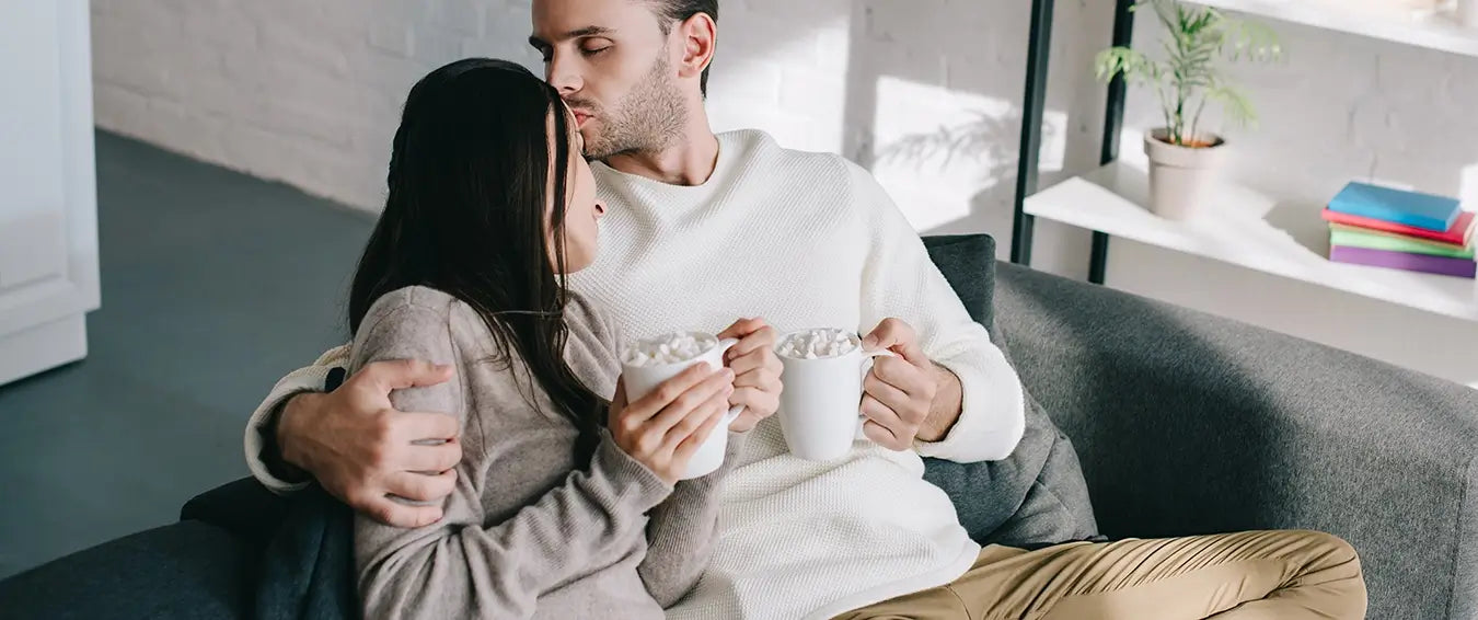 couple having hot chocolate on the couch