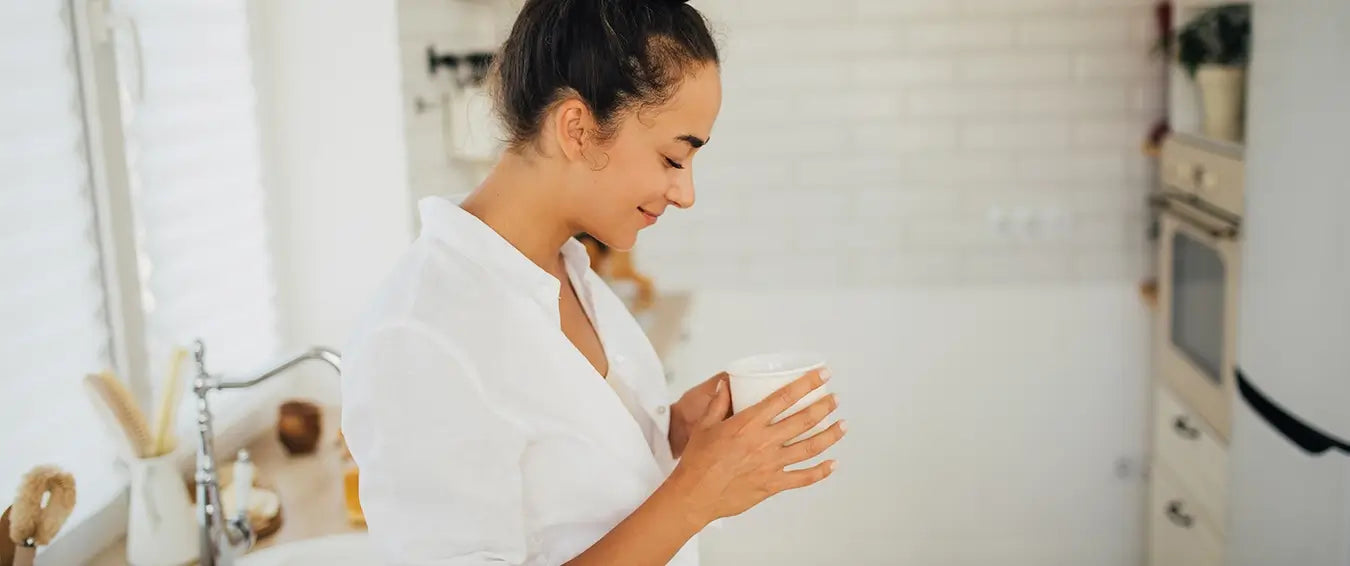 morning rituals, woman in kitchen with beverage