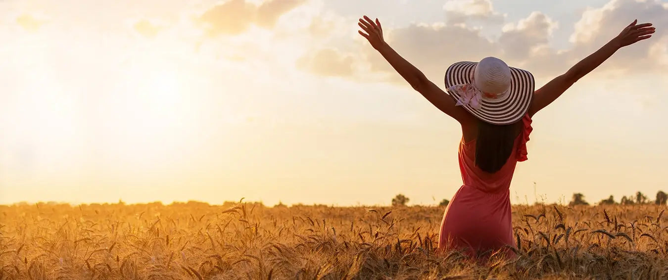 woman with her arms open looking at sunset