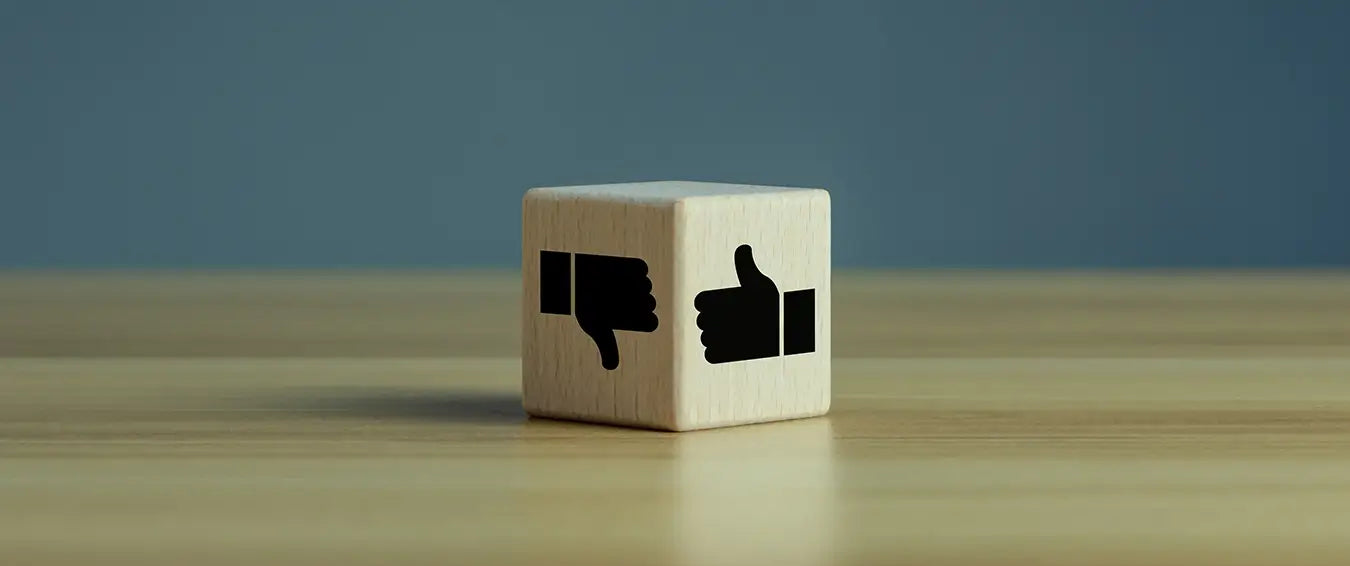 a wooden cube with thumb up on one of its face, and a thumb down on another one