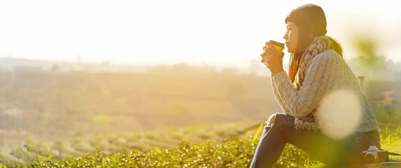 cozy woman enjoying a cup of coffee outdoors